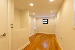 Chicago apartment for rent - A long hallway with wood floors and white walls.