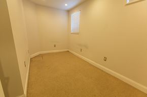 Chicago apartment for rent - A room with a carpeted floor and a window with blinds.
