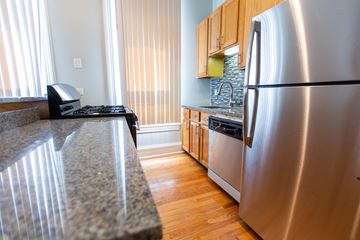 Chicago apartment for rent - A kitchen with a granite counter top and a stainless steel refrigerator.