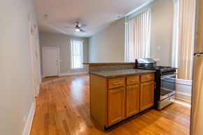 Chicago apartment for rent - A kitchen with wooden cabinets and a stove top oven.