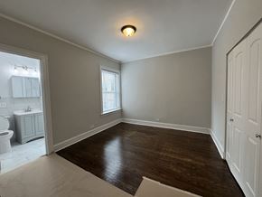 Chicago apartment for rent - A room with wooden floors and white walls.