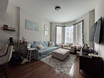 Chicago apartment for rent - A living room with a grey couch and a white chair.