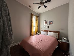 Chicago apartment for rent - A bedroom with a bed, nightstand, and a ceiling fan.