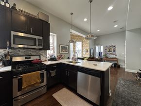Chicago apartment for rent - A kitchen with dark brown cabinets and a stainless steel dishwasher.