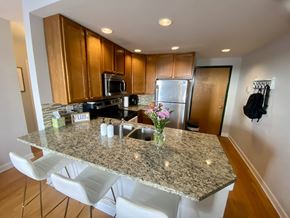 Chicago apartment for rent - A kitchen with granite countertops and white chairs.