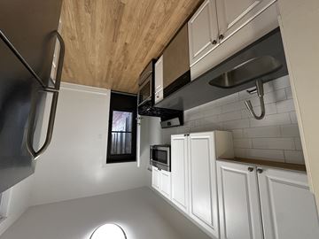 Chicago apartment for rent - A modern kitchen with white cabinets and a wooden ceiling.