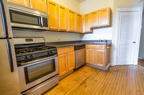 Chicago apartment for rent - a kitchen with wood flooring and stainless steel appliances and wooden cabinets