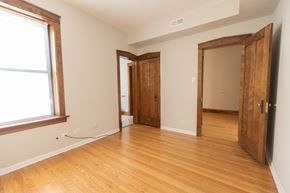 Chicago apartment for rent - A room with wooden floors and a window on the left side.