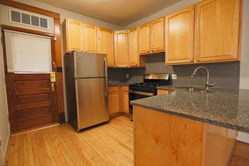 Chicago apartment for rent - A kitchen with wooden cabinets and a granite counter.