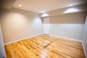 Chicago apartment for rent - A room with wooden flooring and a white door.