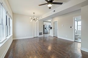 Chicago apartment for rent - A spacious room with a ceiling fan and hardwood floors.