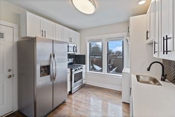 Chicago apartment for rent - A kitchen with white cabinets and a stainless steel refrigerator.