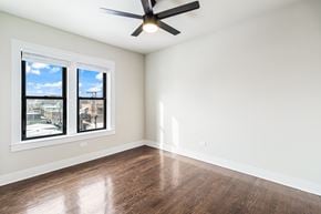 Chicago apartment for rent - A room with a ceiling fan and two windows.
