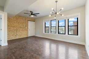 Chicago apartment for rent - A room with a brick wall and a ceiling fan.