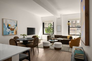 Chicago apartment for rent - A modern living room with a white dining table and brown chairs.