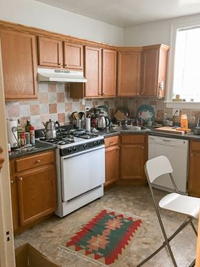 Evanston apartment for rent - A kitchen with wooden cabinets and a white stove top oven.