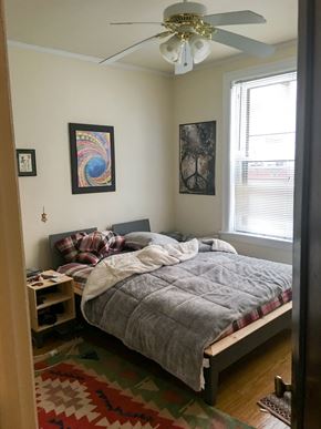 Evanston apartment for rent - A bedroom with a bed, a ceiling fan, and two pictures on the wall.