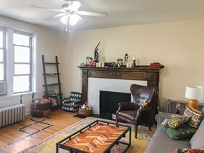 Chicago apartment for rent - A living room with a fireplace and a brown leather chair.