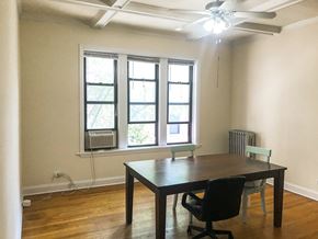 Chicago apartment for rent - A room with a table and chairs and a window with an air conditioner.