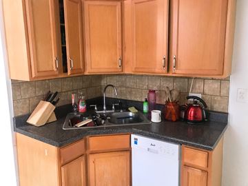 Chicago apartment for rent - A kitchen with wooden cabinets and a white dishwasher.