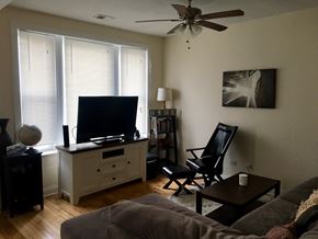 Chicago apartment for rent - A living room with a grey couch and a black chair.