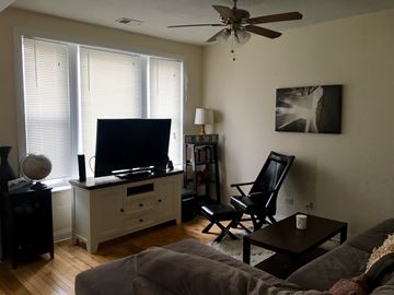 Chicago apartment for rent - A living room with a grey couch and a black chair.
