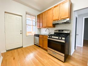 Chicago apartment for rent - A kitchen with wooden cabinets and a black stove top oven.