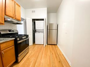 Chicago apartment for rent - A kitchen with wooden cabinets and a black stove top oven.
