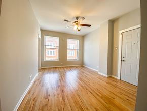 Chicago apartment for rent - A room with wooden floors and a ceiling fan.