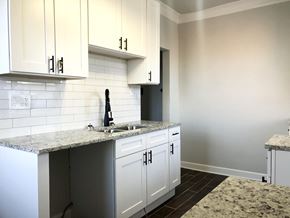 Chicago apartment for rent - A kitchen with granite countertops and white cabinets.