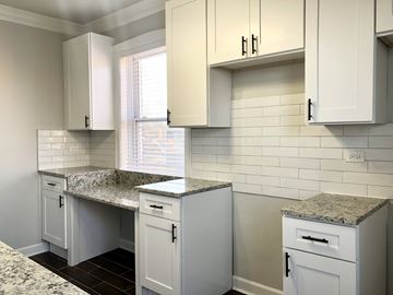 Chicago apartment for rent - A kitchen with white cabinets and granite countertops.
