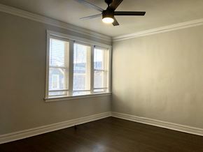 Chicago apartment for rent - A room with a ceiling fan and a window with blinds.
