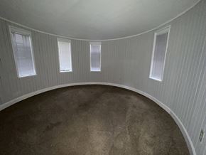 Chicago Il apartment for rent - A round room with three windows and a carpeted floor.