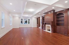 Chicago apartment for rent - A spacious room with wooden floors and a fireplace.