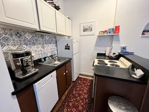 Chicago apartment for rent - A kitchen with a white fridge and a black counter top.