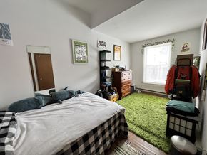 Chicago apartment for rent - A bedroom with a bed, dresser, and window.
