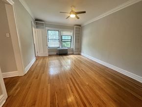 Evanston apartment for rent - an empty living room with wood floors and a ceiling fan