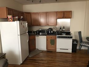 Chicago apartment for rent - A kitchen with wooden cabinets and a white refrigerator.