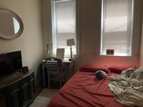 Chicago apartment for rent - A bedroom with a red bedspread and a grey blanket.