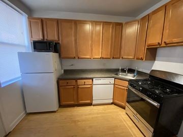 Chicago apartment for rent - A kitchen with wooden cabinets and a white refrigerator.