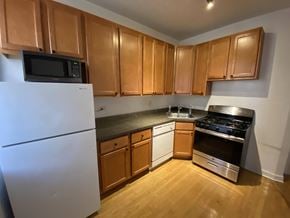 Chicago apartment for rent - A kitchen with wooden cabinets and a white refrigerator.