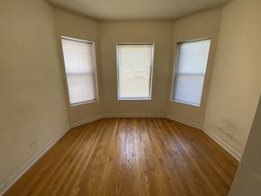 Chicago apartment for rent - A room with wooden floors and two windows.