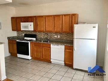 Chicago apartment for rent - a kitchen with white appliances and wooden cabinets