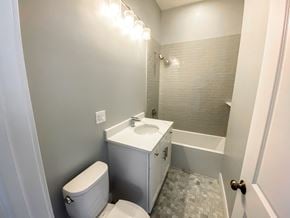 Chicago apartment for rent - A white toilet sits next to a sink in a bathroom.