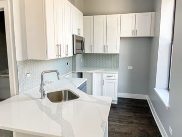 Chicago apartment for rent - A kitchen with white cabinets and a white counter top.