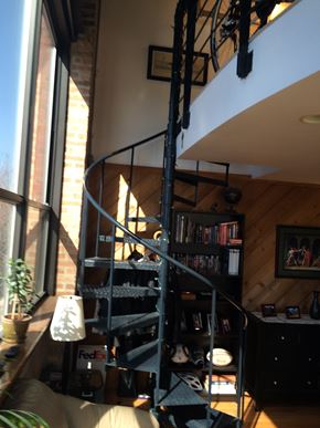 Chicago apartment for rent - A spiral staircase in a home with a black metal railing.