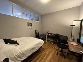 Chicago apartment for rent - A bedroom with a bed, desk, chair, and a window.