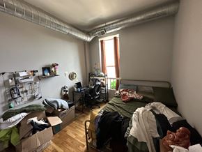 Chicago apartment for rent - A room with a bed, desk, and clutter.