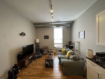 Chicago apartment for rent - A living room with a grey couch and a wooden floor.