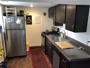 Chicago apartment for rent - A kitchen with a stainless steel refrigerator and dark brown cabinets.